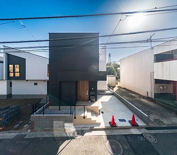 シャープなラインが際立つモダンなシルエット。並列駐車可能なスペースを確保し、デザイン性と利便性を両立した都市型邸宅です。