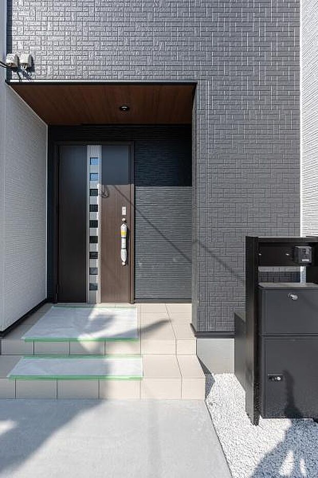 重厚感ある黒のアクセント壁が目を引く玄関ポーチ。宅配ボックス完備で、外出中も荷物を受け取れる利便性が魅力です。