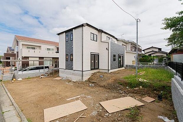 落ち着いた色合いのモダンな外観。前面にはお車の出し入れがしやすい、ゆとりある平坦なカースペースを備えています。