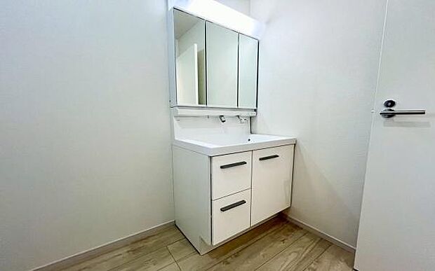 《洗面化粧台》　■洗面化粧台の鏡は、メイクや髭剃りに便利な三面鏡タイプ。開いて合わせ鏡としても使用できます。洗面台サイドには収納スペースとして利用でき、小物などの保管に便利な棚も付いています。