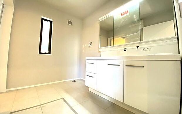 《洗面化粧台》　■洗面化粧台の鏡は、メイクや髭剃りに便利な三面鏡タイプ。開いて合わせ鏡としても使用できます。鏡の裏側は収納スペースとして利用でき、小物などの保管に便利な棚も付いています。