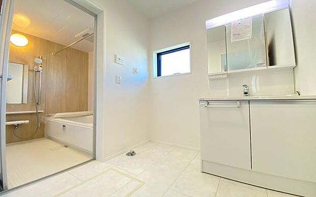 《洗面化粧台》　■洗面化粧台の鏡は、メイクや髭剃りに便利な三面鏡タイプ。開いて合わせ鏡としても使用できます。鏡の裏側は収納スペースとして利用でき、小物などの保管に便利な棚も付いています。