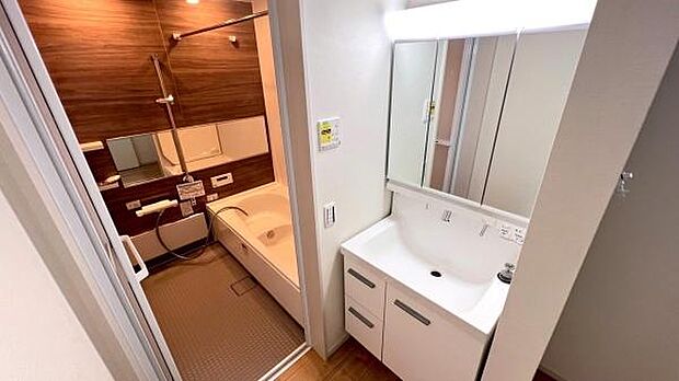 《洗面化粧台》 ■洗面化粧台の鏡は、メイクや髭剃りに便利な三面鏡タイプ。開いて合わせ鏡としても使用できます。洗面台サイドには収納スペースとして利用でき、小物などの保管に便利な棚も付いています。