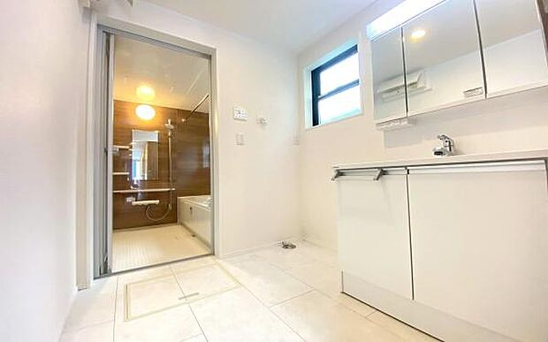 《洗面化粧台》　■洗面化粧台の鏡は、メイクや髭剃りに便利な三面鏡タイプ。開いて合わせ鏡としても使用できます。鏡の裏側は収納スペースとして利用でき、小物などの保管に便利な棚も付いています。