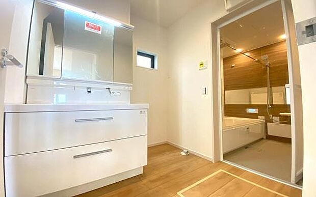 《洗面化粧台》　■洗面化粧台の鏡は、メイクや髭剃りに便利な三面鏡タイプ。開いて合わせ鏡としても使用できます。鏡の裏側は収納スペースとして利用でき、小物などの保管に便利な棚も付いています。