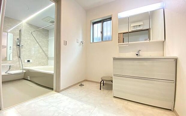 《洗面化粧台》　■洗面化粧台の鏡は、メイクや髭剃りに便利な三面鏡タイプ。開いて合わせ鏡としても使用できます。鏡の裏側は収納スペースとして利用でき、小物などの保管に便利な棚も付いています。