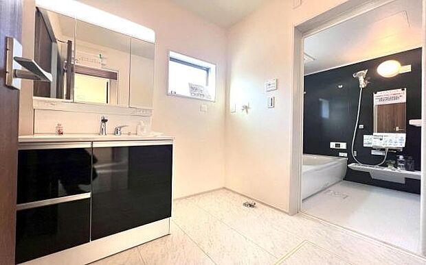 《洗面化粧台》　■洗面化粧台の鏡は、メイクや髭剃りに便利な三面鏡タイプ。開いて合わせ鏡としても使用できます。鏡の裏側は収納スペースとして利用でき、小物などの保管に便利な棚も付いています。