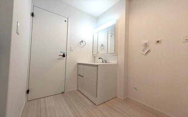 《洗面化粧台》　■洗面化粧台の鏡は、メイクや髭剃りに便利な三面鏡タイプ。開いて合わせ鏡としても使用できます。鏡の裏側は収納スペースとして利用でき、小物などの保管に便利な棚も付いています。