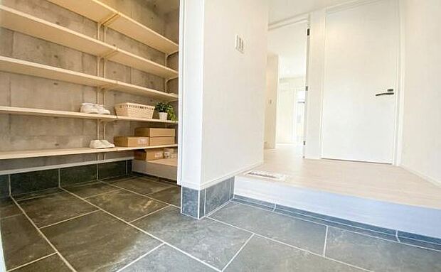 《玄関》 ■ナチュラルな木棚が調和するシューズインクローク。大容量収納で玄関はいつもすっきり。上質なタイル仕上げとのコントラストが、帰宅のたびに洗練された空間を演出します。