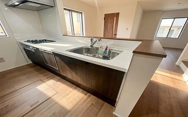 《システムキッチン》　■採光豊かな明るい空間に広がる、スタイリッシュな対面キッチン。対面式だからリビングとの一体感があり、家族との会話を楽しみながら料理できる。食卓を囲む時間が、より豊かに彩られる。