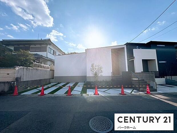 直線を生かしたモダンな平屋。白の外壁に深い庇と木目の玄関が映える上質なファサード