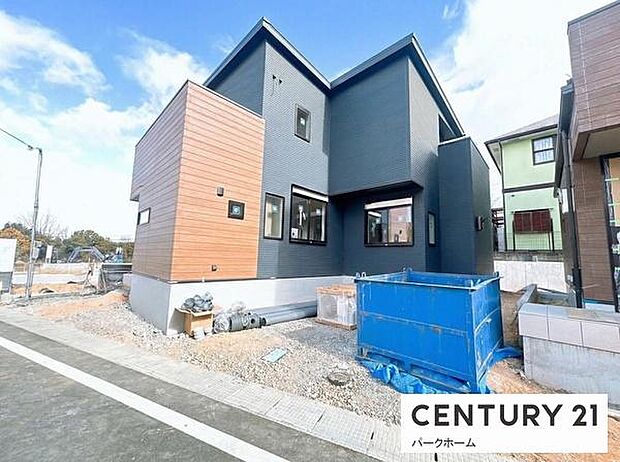 豊かな緑を背景に佇む、モダンで温かみのある新築住宅です。玄関周りの木目調デザインが、訪れる人を優しく迎え入れます。日当たりも良く、明るい新生活を予感させる一邸。