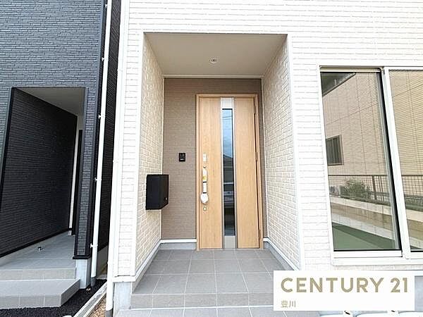 木目調のドアが温かみを感じさせる玄関ポーチ。屋根付きのポーチ庇が施されており、雨の日のお出かけや帰宅時にも落ち着いて対応できます。