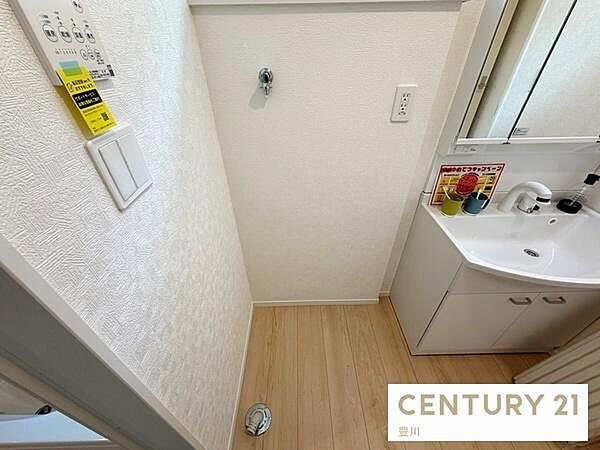 洗面台の横に洗濯機設置スペースを確保した機能的な洗面室です。壁面にはスイッチパネルやコンセントが配置されており、水回りの家事動線もスムーズにこなせます。
