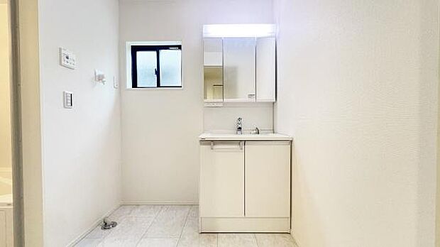 《洗面化粧台》　■洗面化粧台の鏡は、メイクや髭剃りに便利な三面鏡タイプ。開いて合わせ鏡としても使用できます。鏡の裏側は収納スペースとして利用でき、小物などの保管に便利な棚も付いています。