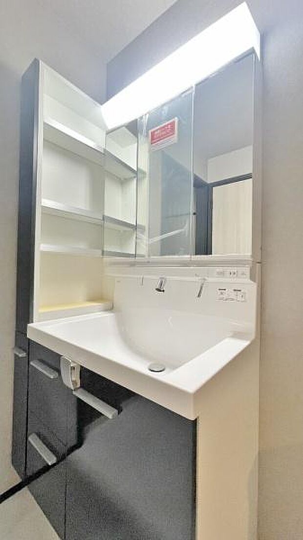 《洗面化粧台》　■洗面化粧台の鏡は、メイクや髭剃りに便利な三面鏡タイプ。開いて合わせ鏡としても使用できます。洗面台サイドには収納スペースとして利用でき、小物などの保管に便利な棚も付いています。