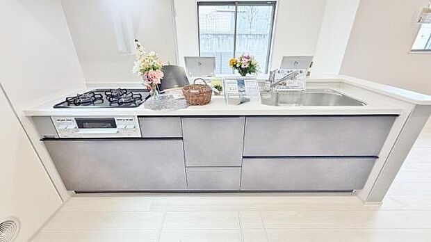 《システムキッチン》　■採光豊かな明るい空間に広がる、スタイリッシュな対面キッチン。対面式だからリビングとの一体感を感じ、家族との会話を楽しみながら料理できる。食卓を囲む時間が、より豊かに彩られる