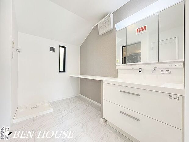 洗面室・使い勝手の良い、三面鏡付き洗面台を設置した洗面脱衣室。タオルなどの収納に便利な棚が備え付けられています。