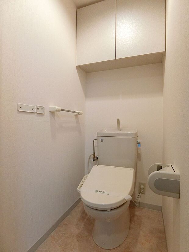 備品や小物の収納に便利な扉付きの棚のあるトイレ