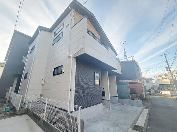 幅員のある前面道路に面した現地写真です。車の出し入れがしやすく周囲も落ち着いた雰囲気の住宅街です。建物外観はスタイリッシュなデザインで清潔感があります。街並みとの調和が感じられる一枚です。