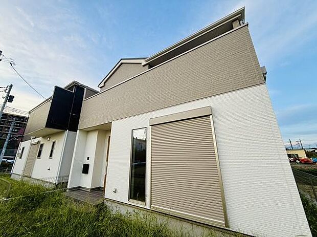 シンプルな外観が特徴的です。シャッター付きの窓が設置されています。清潔感のある色合いでまとめられています。落ち着いた雰囲気の住宅です。角地に位置している印象があります。