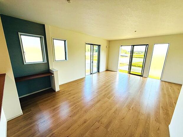 大きな窓からたっぷりと自然光が差し込むリビングです。フローリングが明るい印象を演出しています。壁面にはアクセントカラーが施され空間に程よい変化をもたらします。開放感のある広々とした空間です。