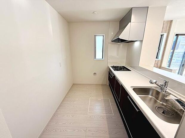 シンプルなデザインが印象的なキッチンです。窓があり明るい空間が広がります。収納も豊富で使い勝手の良いレイアウトです。作業スペースもしっかり確保されています。清潔感のある仕上がりです。