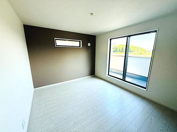 大きな窓からたっぷりと日差しが差し込む明るい洋室です。シンプルなデザインでさまざまなインテリアに合わせやすい空間となっています。アクセントウォールが落ち着いた雰囲気を演出します。