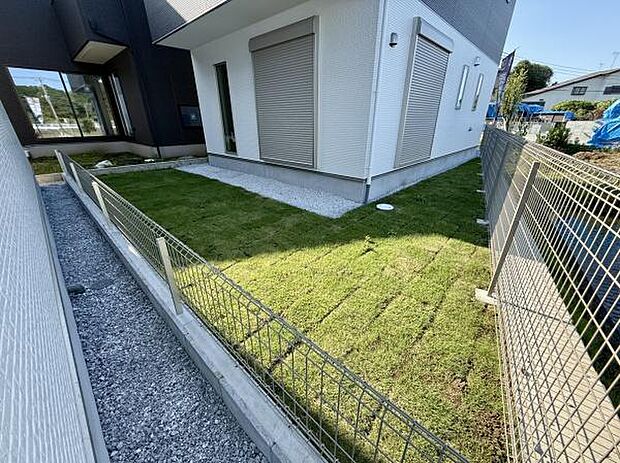陽当たりの良い庭が広がりゆったりとしたスペースが確保されています。外構フェンスが設置されておりプライバシーにも配慮された設計です。手入れの行き届いた芝生が敷かれ清潔感が感じられます。