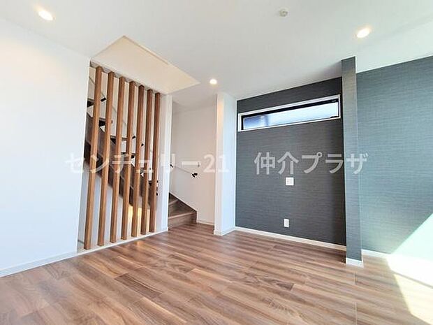 このリビングはモダンなデザインと落ち着いた雰囲気が魅力です。木目調のフローリングが暖かみを感じさせ階段のデザインが個性的です。明るい光が差し込む空間で快適に過ごせます。