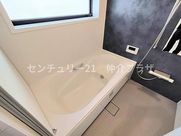 心地よい時間を過ごせる広々としたバスタブが魅力です。モダンな壁面デザインが洗練された印象を与えます。明るい窓からの採光で毎日のバスタイムが特別なひとときに変わります。