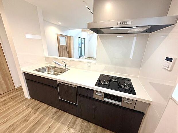 キッチン全体が明るく清潔感があります。ワークトップが広く使いやすそうな設計です。収納スペースも豊富で片付けがしやすいです。ガスコンロや換気扇もスマートなデザインとなっています。