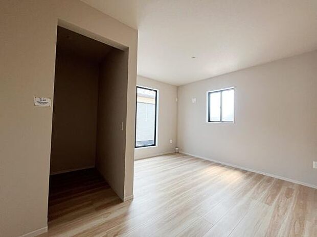 二面採光で明るい雰囲気のリビングです。シンプルな内装が特徴的です。ナチュラルな床材が空間に広がりを感じさせます。使いやすさが魅力です。収納スペースも備わっています。