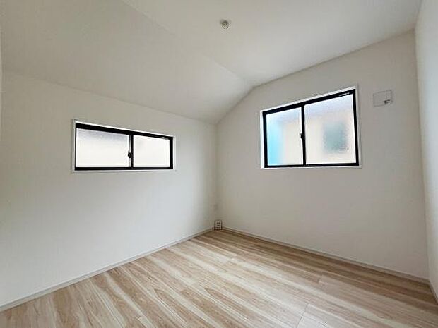 明るい色合いのフローリングが清潔感を感じさせる洋室です。窓が二方向にあり自然光がしっかり入ります。壁や天井もシンプルなデザインでさまざまなインテリアと調和します。天井が高めで開放感があります。
