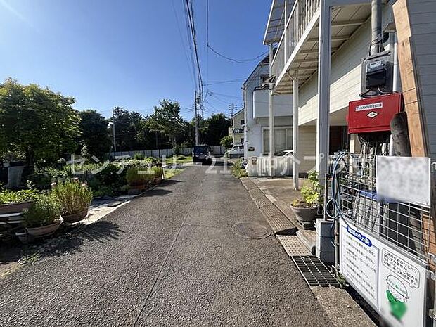 前面道路は落ち着いた雰囲気で交通量も少なめです。周辺には緑が多く開放感があります。現地は明るい日差しが差し込む立地です。道路幅も確保されており歩きやすい印象です。