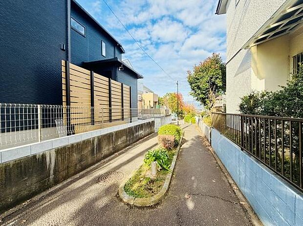住宅街の一角に位置し陽当たりの良い明るい道路沿いです。周囲の植栽がきちんと手入れされておりすっきりとした印象です。幅の広い道路が開放感をもたらしています。静かな環境で落ち着いた雰囲気が感じられます。