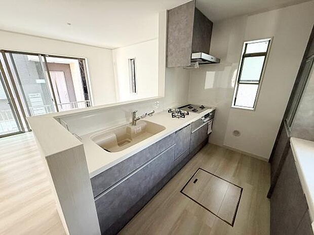 キッチンは広々としたワークトップと収納スペースが魅力です。3口コンロで調理がはかどります。窓があり明るさと換気にも配慮されています。シンクも大きく使い勝手が良い印象です。