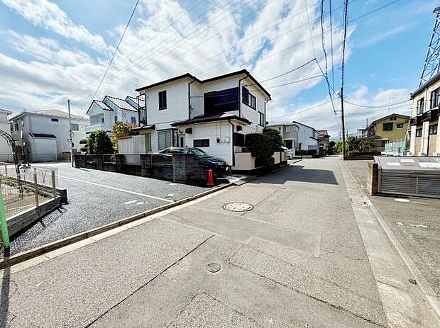 現地の前面道路は広々とした印象で車の出入りがしやすい環境です。周囲の住宅も整然としており落ち着いた街並みが魅力です。道路沿いには駐車スペースも確保されています。