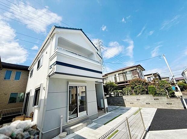 2号棟。爽やかな青空の下に建つ外観が印象的な住宅です。広々とした駐車スペースが確保されており車の出し入れもスムーズに行えます。周囲との調和が取れた落ち着いた環境が魅力です。