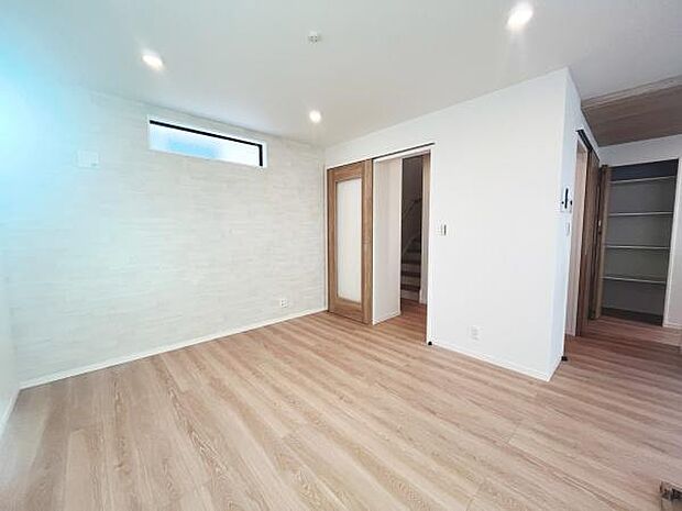 明るいフローリングが空間に温かみを与えています。壁にはシンプルなアクセントがあり清潔感が漂います。収納スペースも備わっておりすっきりとした印象です。室内は余裕のある広さで自由なレイアウトが楽しめます。