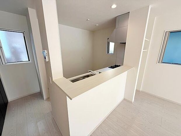 開放的なカウンターキッチン仕様で全体が明るい印象です。2面に窓があり採光や換気に配慮されています。収納や作業スペースも確保されており機能的な設計です。清潔感のあるホワイトを基調とした空間が特徴です。