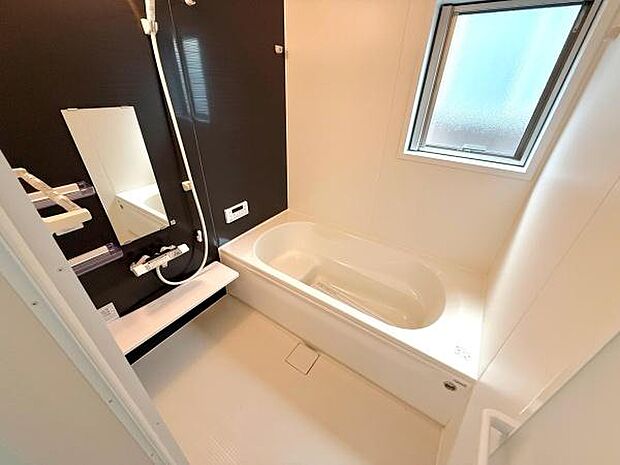 シンプルなデザインのバスルームです。浴室にはしっかりとした換気用の窓があり明るさも感じられます。壁面には使いやすいシャワーや鏡が備え付けられています。すっきりとした印象の空間です。