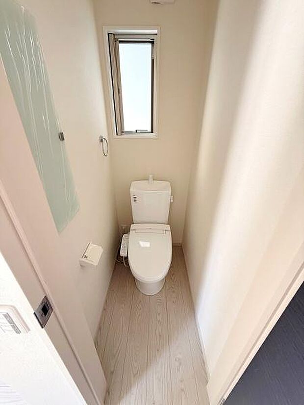 明るい光が入る窓付きのトイレです。清潔感のある内装が特徴です。スペースを有効活用した造りになっています。シンプルなデザインでお手入れも簡単です。