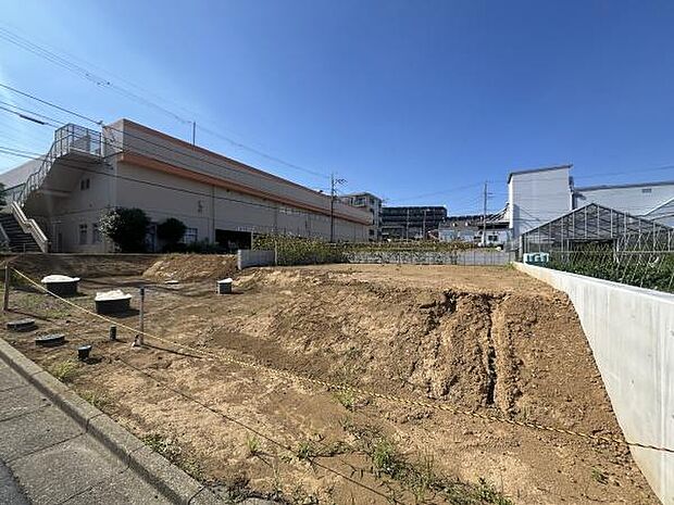 日当たりの良い現地土地写真です。周辺には生活関連施設が集まっています。土地の形状も確認しやすく敷地の使い方を検討しやすい環境です。道路に面しておりアクセスも便利です。