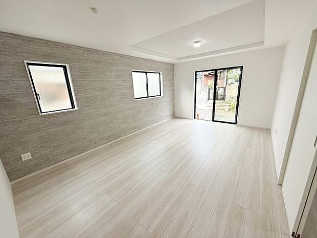 明るい光が差し込むリビングです。壁と床の色合いが調和しており広がりを感じられます。窓が多く通風も良好です。室内がすっきりとして家具の配置もしやすい設計です。開放感のある空間が特徴です。