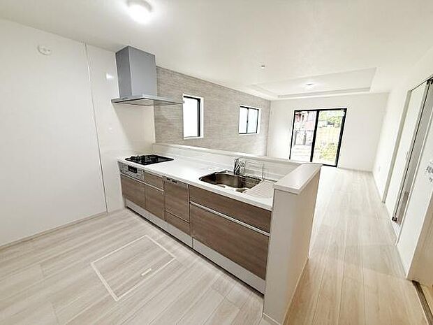 明るい色合いの床材と壁面がキッチン全体をすっきりとした印象にしています。広々とした作業スペースが確保されており使い勝手の良さが感じられます。大きな窓から自然光が差し込み室内を明るく演出しています。