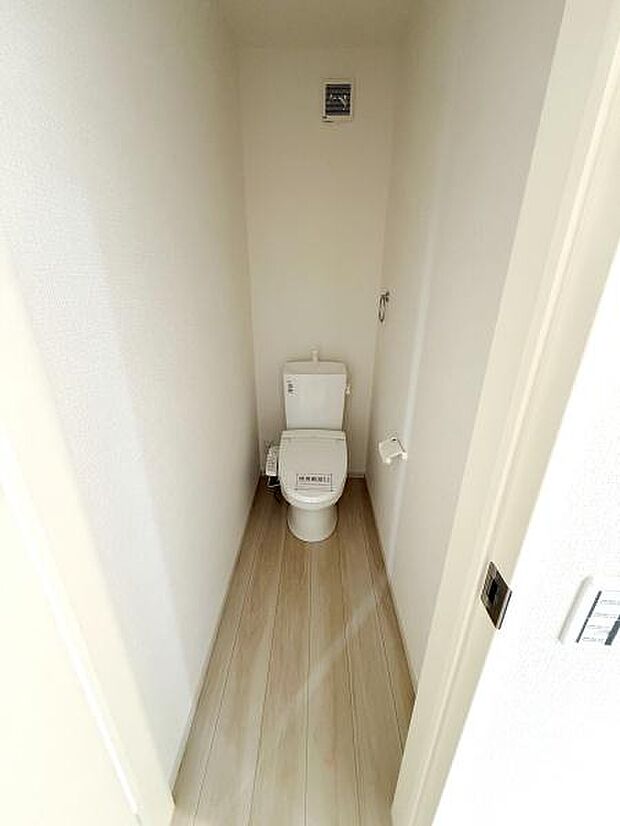 落ち着いたホワイトを基調とした清潔感のあるトイレです。シンプルなデザインで使いやすい空間となっています。床の明るい色合いがより広く感じさせてくれます。