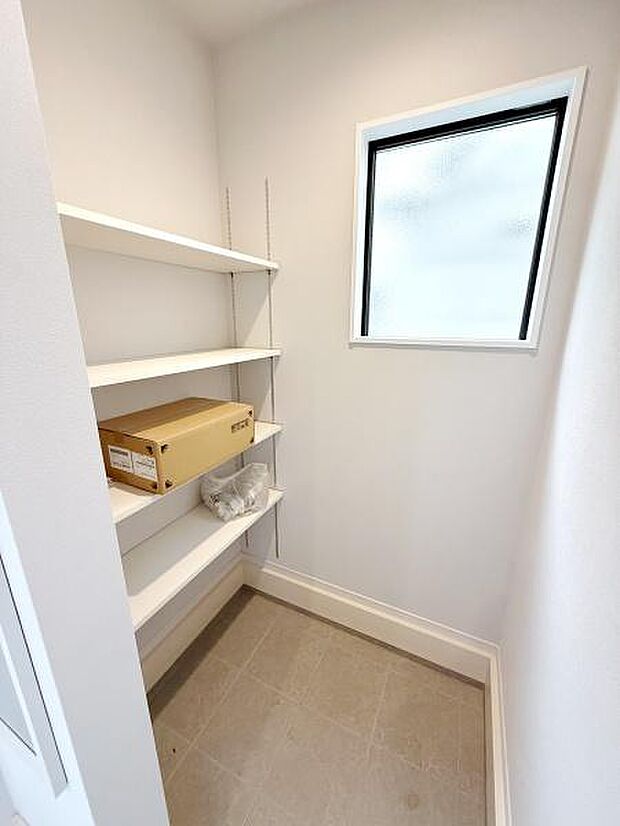 シンプルな内装で使い勝手の良い収納スペースです。採光窓があり明るい空間が印象的です。棚が設置されており小物の整理にも便利です。清潔感のあるデザインが特徴です。