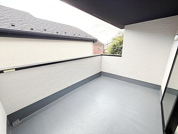 開放感のある広々としたバルコニーです。外からの視線を遮る壁が設置されており安心して過ごせる空間です。雨天時にも活用しやすい屋根付きで便利です。床面はお手入れがしやすい素材となっています。