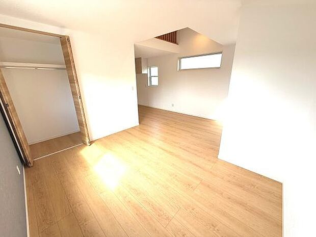 リビングには明るい陽射しが差し込み温かみのある木目調の床が空間を引き立てています。シンプルで余裕のある間取りとなっており使いやすさが特徴です。クローゼットの扉もナチュラルな雰囲気を演出しています。